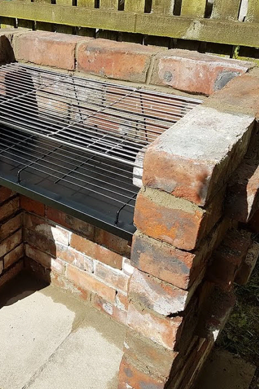 outdoor kitchen with grill and wood wall